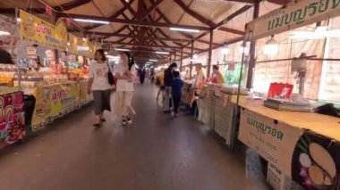 Alışveriş yapanlar kapalı bir markette yürüyorlar.