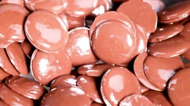 Çikolata diskleri eriyor ve yakın çekimde hareket ediyor.