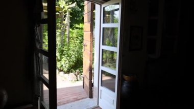 Açık bir kapıdan sakin bir bahçe sahnesi