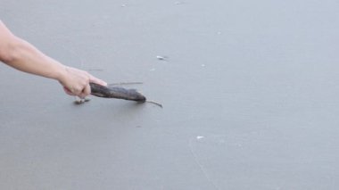 Kumlu sahilde aşk sözcüğü kazınıyor.