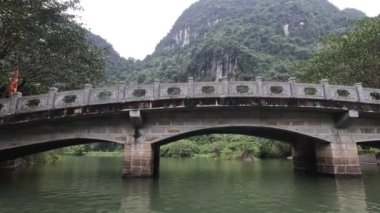 Ninh Binh 'de taş bir köprünün altından geçiyor.