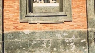 Tuğla bir cepheden bir heykel çıkıyor.