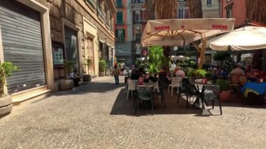 İnsanlar kafede güneşli bir günün tadını çıkarıyorlar.