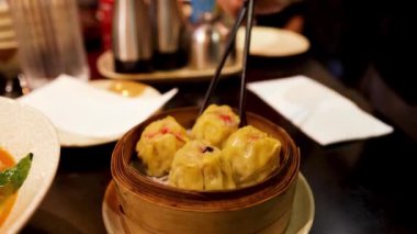 Yemek çubuğuyla hamur köftesi toplayan kişi.