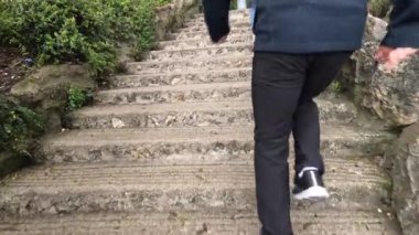 İnsanlar bahçede taş basamaklara tırmanıyor.