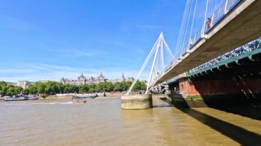 Hungerford Köprüsü 'nün altındaki Thames nehrinde gemiler geziniyor.