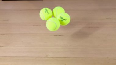 Bir dizi tenis topu zıplıyor ve dağılıyor.