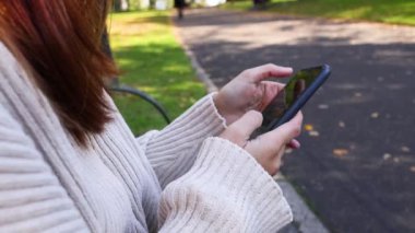 Parkta akıllı telefonla iletişim kuran kişi