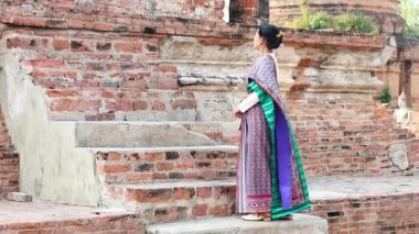 Geleneksel Tayland elbiseli kadın eski basamakların yanında
