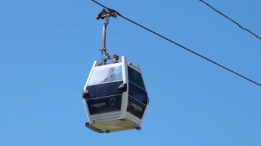 Açık mavi gökyüzünde hareket eden kablo araba