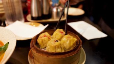 Lokantada çubuklarla hamur tatlısı yiyen biri.