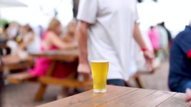 İnsanlar masanın etrafında bira ile sosyalleşiyorlar.