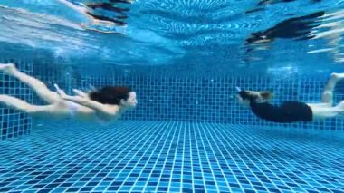 Suyun altında yüzmekten zevk alan iki insan.