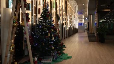 Aydınlatılmış Noel ağaçları güzel dekore edilmiş bir koridor.