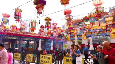 İnsanlar canlı tapınak süslemelerinin arasında dua ediyorlar.