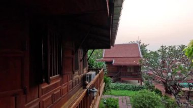 Yeşillik ve nehri olan geleneksel Tayland evi.