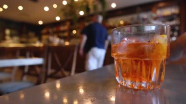 Barda Aperol Spritz 'e uzanan el.