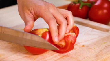 Tahta kesme tahtasında domates dilimlemek.