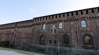 Sforzesco Kalesi 'nin yanından geçen iki kişi.
