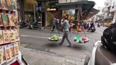 Hawker omuz direği ve sepetlerle yürüyor.