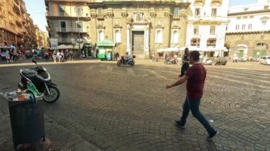 İnsanlar tarihi bir Napoli meydanında yürüyor