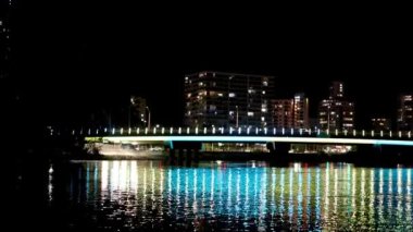 Şehir ışıkları geceleri suyu yansıtıyor.