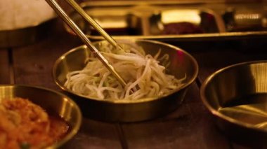 Fasulye filizlerini ustalıkla toplamak için çubuk kullanmak.