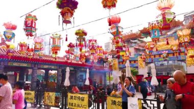 İnsanlar renkli tapınakta tütsüyle dua ediyorlar.