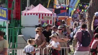 Renkli kabinleri ve ziyaretçileri olan kalabalık festival sahnesi