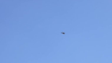 Açık mavi gökyüzünde uçan bir helikopter