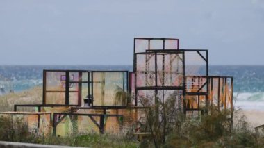 İnsanlar renkli plaj sanat tesislerinin önünden geçiyorlar.