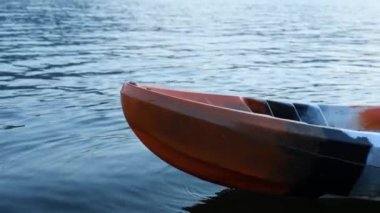 Bir kano süzülür ve sakin bir gölde yavaşça hareket eder..