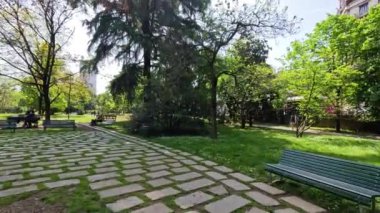 Milano parkında güneşli bir günün tadını çıkaran insanlar