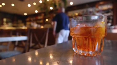 Barda Aperol Spritz 'e uzanan el.