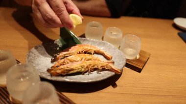 Japon restoranında ızgara balık yiyen biri.