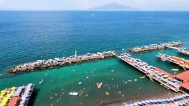 Plajın ve denizin tadını çıkaran turistler