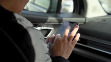 Arabada cep telefonu kullanan biri.