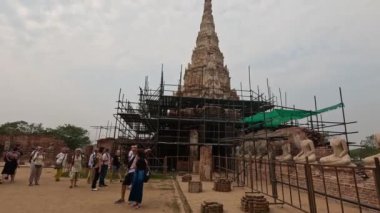 Tarihi bir tapınağı gezen turistler restorasyon altında