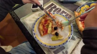 Restoranda pizza yiyen biri.