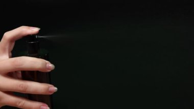 Koyu bir şişeden sıvı püskürten bir elin sekansı.