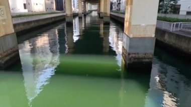 Su beton bir köprünün altından akıyor..