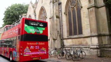 Oxford 'da tarihi kiliseyi geçen kırmızı otobüs.