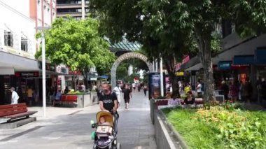 Şehir ortamında bebek arabasıyla yürüyen kişi