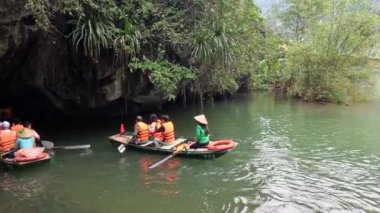 Sakin bir nehir mağarasında kürek çeken turistler