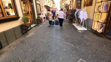 İnsanlar işlek bir alışveriş caddesinde yürüyor