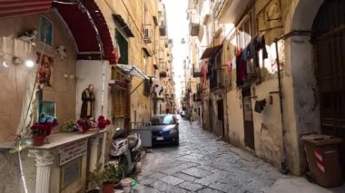 Napoli 'de dar bir sokakta park etmiş bir araba var.