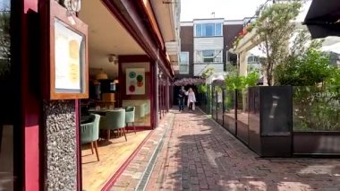 İnsanlar Brighton 'da bir kafenin önünden geçiyor.