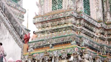Turistler Wat Arun 'un detaylı tapınak tasarımına hayranlar.