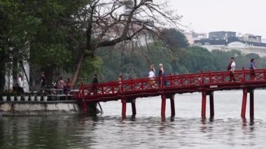 İnsanlar Hanoi, Vietnam 'da kırmızı bir köprüden geçiyor.