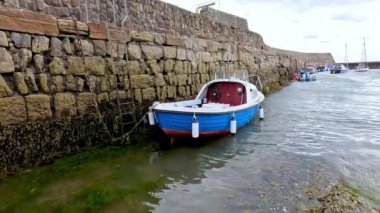 Taş bir duvara kenetlenmiş bir tekne.